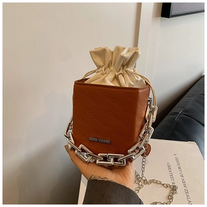 Close-up of retro brown leather bucket bag with silver chain handle and inner drawstring