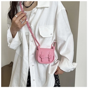Gros plan sur le mini sac bandoulière rose avec rabat à deux boucles et fine lanière