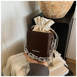 Close-up of brown bucket bag with rich rabbit embossing and silver chain detail