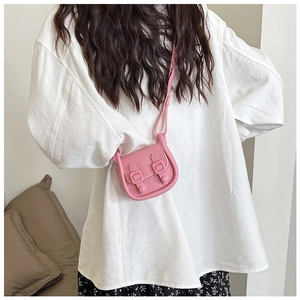 Vue détaillée d'un mini sac bandoulière rose porté par un mannequin en robe à fleurs