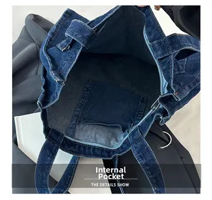 Detail shot of denim tote bag showing spacious interior and a secure zippered pocket