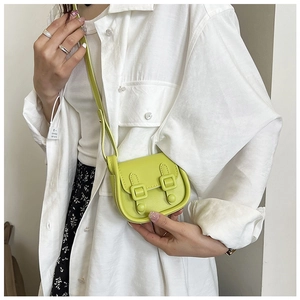 Mini sac à bandoulière vert citron minimaliste porté par un mannequin en robe fleurie