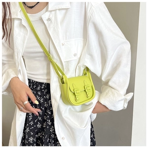 Détail d'un mini sac bandoulière vert clair avec fermeture magnétique à double boucle pour femme