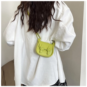 Mini sac bandoulière vert avocat avec boucles vintage porté par un mannequin
