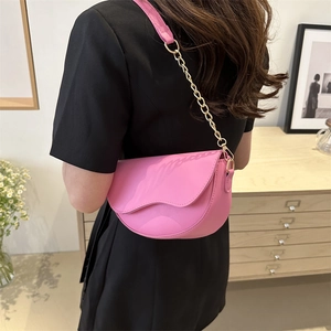 Pink matte leather saddle bag with wave design and gold chain strap on model
