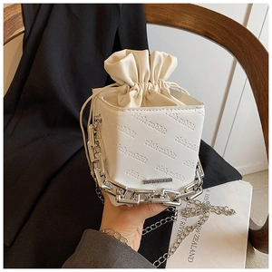 Detail of white PU leather bucket bag with rich rabbit embossing and silver chain handle