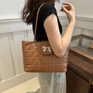 Brown quilted underarm bag with silver bow buckle and gold chain strap for women