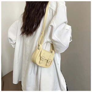Sac bandoulière beige minimaliste sur modèle avec sangle réglable et rabat décoratif chic