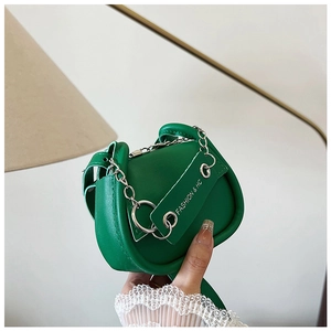 Detail der grünen Mini-Satteltasche mit Silberkette und FASHION & HC Logo-Tag