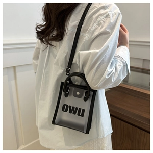 Détail du sac à main en PVC transparent avec lettrage OWU noir et finitions en cuir