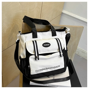 Detail der Canvas-Tragetasche mit Klapptasche vorne und verstellbarem Schultergurt-Design