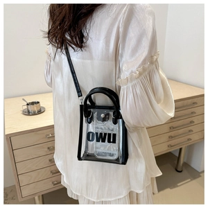 Détail d'un mini sac transparent en PVC avec lanières en cuir noir et impression OWU