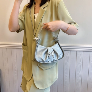 Silver pleated crescent bag with metal chain and transparent bead handle on model