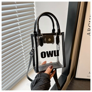Vue détaillée d'un sac à main en PVC transparent avec garniture noire et lettrage OWU