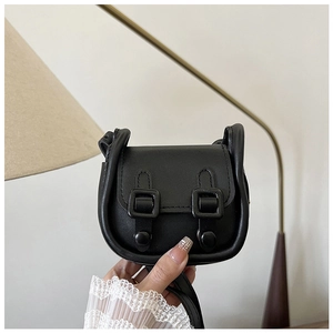 Détail d'un mini sac bandoulière en cuir noir vintage avec fermeture à double bouton