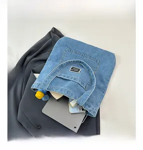 Blue denim tote bag showing large capacity with tablet, phone, and daily essentials inside