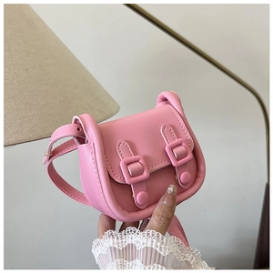 Gros plan détaillé d'un mini sac bandoulière rose avec doubles boucles et texture en cuir