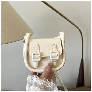 Détail d'un mini sac carré blanc crème montrant le cuir PU texturé et le design à rabat