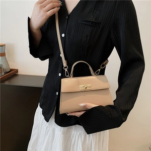 Elegant beige leather crossbody handbag with gold metal lock and top handle for women
