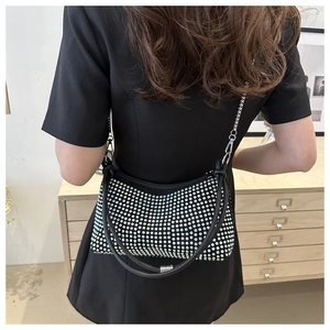 Close-up of sparkling rhinestone shoulder bag with silver chain strap on model