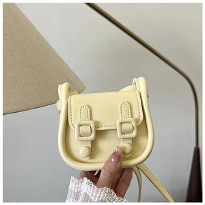 Gros plan d'un mini sac bandoulière jaune clair avec sangles décoratives en cuir PU souple