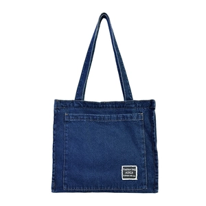 Large dark blue denim tote bag with front pocket and fashion label for women's daily commute