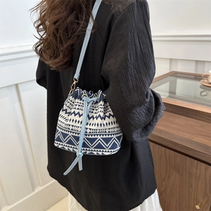 Ethnic style bucket bag in blue and white canvas weave with geometric patterns and drawstrings