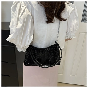 Close-up of black rhinestone shoulder bag with silver chain and metal hardware details