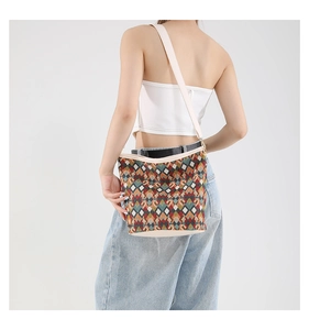 Détail d'un sac seau géométrique avec tissu tissé coloré et bandoulière de couleur crème
