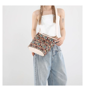 Détail du sac seau tissé géométrique aux couleurs vives et avec une large bandoulière