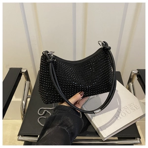 Close-up of a black crescent hobo bag with sparkling rhinestones and chain strap