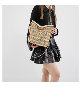 Détail du motif géométrique tissé coloré et des bandoulières en cuir du sac seau