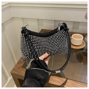 Detail of a chic black underarm bag featuring sparkling silver rhinestones and metal chain strap