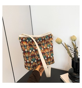 Détail du tissu tissé à motifs de losanges colorés avec finitions en cuir blanc