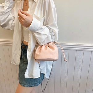 Sac seau rose avec poignée décorative en perles et bandoulière en chaîne métallique