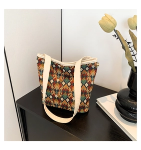 Détail d'un sac seau à motifs géométriques en toile colorée avec de larges anses crème