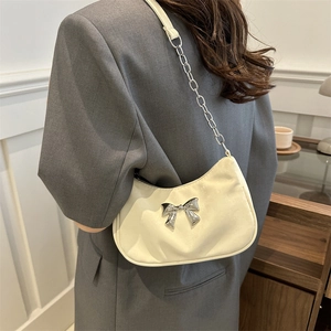 Creamy white crescent underarm bag with silver bow accent and metal chain strap