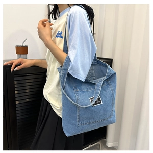 Blue denim tote bag shoulder carry style with fashion patch and spacious main compartment