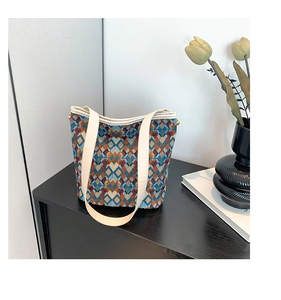 Détail d'un sac seau rétro avec motif géométrique coloré et bandoulières blanc crème
