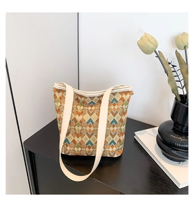 Détail d'un sac seau tissé rétro avec motifs géométriques et bandoulière crème élégante
