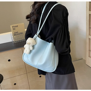 Détail d'un sac cabas bleu clair en cuir PU avec surpiqûres décoratives et breloque ourson