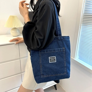 Japanese style deep blue denim tote bag with front pocket carried by a model