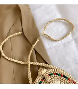 Détail d'un sac bohème tressé avec bordure colorée posé sur un blazer de couleur neutre