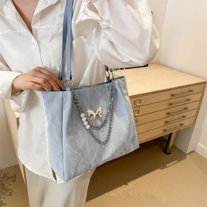 Sac fourre-tout bleu clair avec texture marbre, chaîne argentée et décor papillon