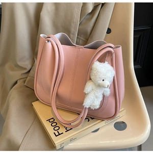 Détail d'un cabas rose pâle avec doubles coutures et un joli porte-clés d'ours blanc en peluche