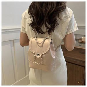 Détail du mini sac à dos beige élégant avec bandoulière chaîne et fermoir tournant