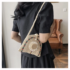 Vue détaillée d'un sac bandoulière en paille beige avec tournesol et bordures colorées