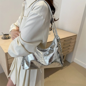 Borsa hobo argento metallizzato con lettere in rilievo e catena d'argento portata da modella