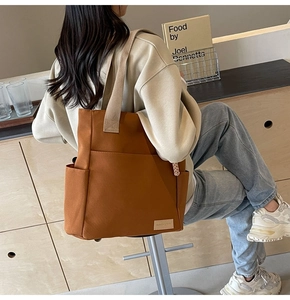 Brown canvas messenger bag featuring multiple pockets and durable shoulder strap details