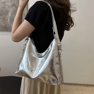 Borsa hobo argento metallizzato con fiocco e tracolla a catena indossata da una modella